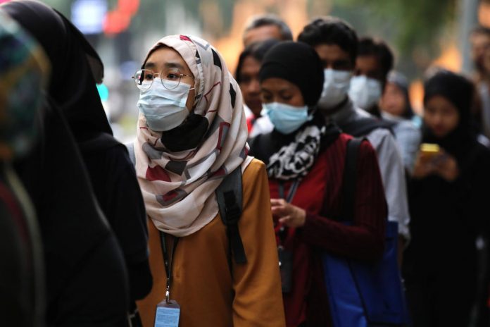 Passengers wear masks to prevent the outbreak of a new coronavirus at a bus station in Kuala Lumpur