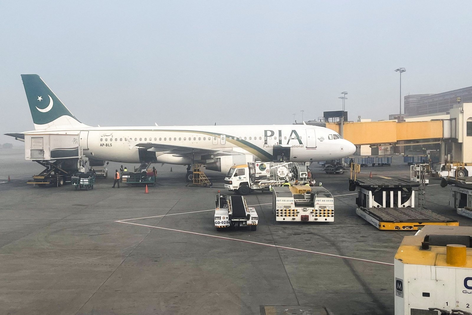 View of a Pakistan International Airlines passengers plane, taken through a glass panel, at the Allama Iqbal International Airpor in Lahore